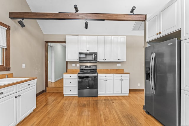 kitchen with appliances with stainless steel finishes, white cabinetry, light countertops, and light wood-type flooring
