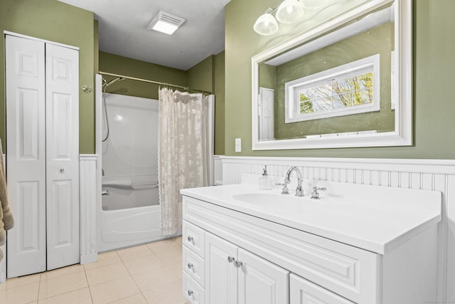 bathroom with wainscoting, tile patterned flooring, vanity, a closet, and shower / bath combination with curtain