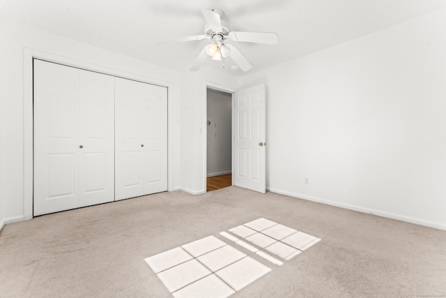 unfurnished bedroom featuring carpet floors, a closet, baseboards, and ceiling fan