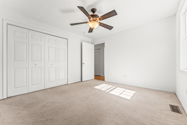unfurnished bedroom featuring carpet floors, a closet, ceiling fan, and baseboards