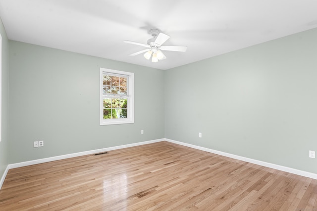 unfurnished room featuring light wood-type flooring, baseboards, and a ceiling fan