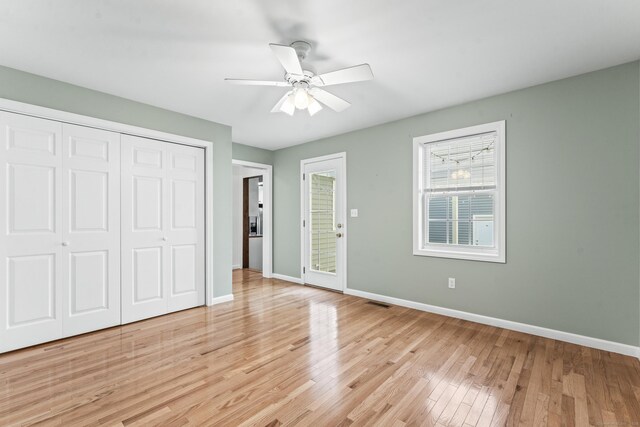 unfurnished bedroom with baseboards, light wood finished floors, a closet, access to exterior, and ceiling fan