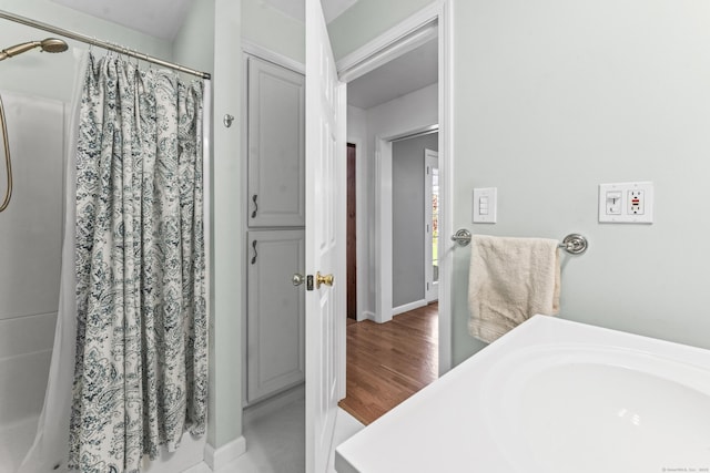 bathroom with a shower with curtain and baseboards