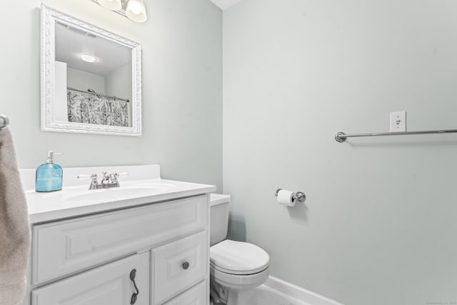 full bathroom featuring vanity, toilet, and baseboards