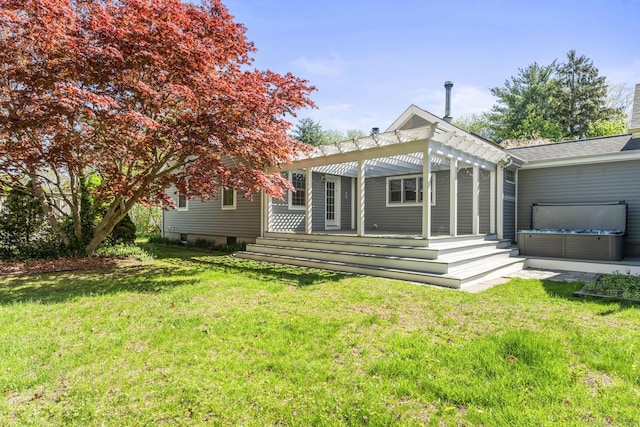 rear view of property featuring a pergola, a hot tub, a deck, and a yard