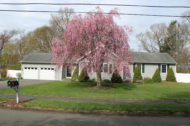 obstructed view of property featuring an attached garage, driveway, and a shingled roof