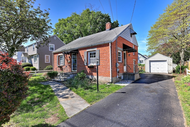 172 Alden St, Fairfield, CT 06824 - view of front of house featuring an outbuilding, a chimney, brick siding, a garage, and asphalt driveway
