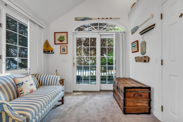 sitting room with healthy amount of natural light, lofted ceiling, carpet, and baseboards
