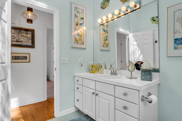 bathroom featuring baseboards, vanity, and wood finished floors