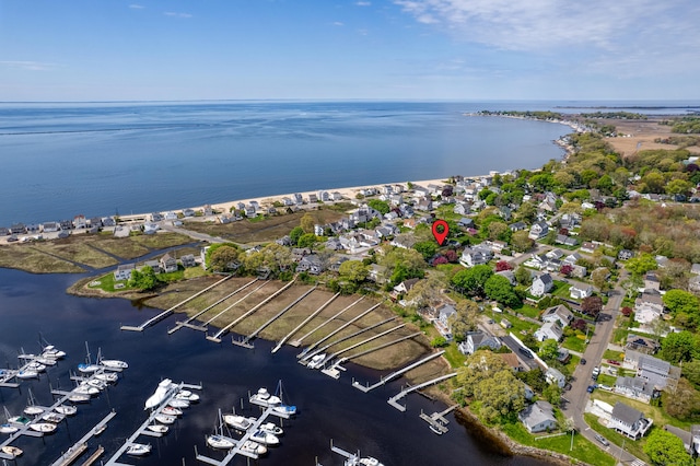 aerial view of property and surrounding area with a nearby body of water and a marina