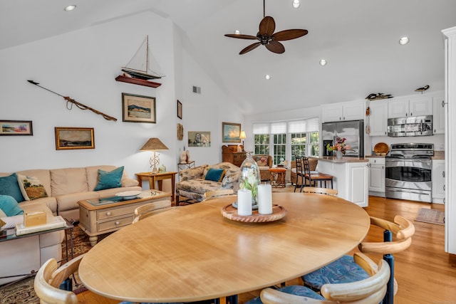 dining space with a ceiling fan, high vaulted ceiling, light wood-style floors, and recessed lighting