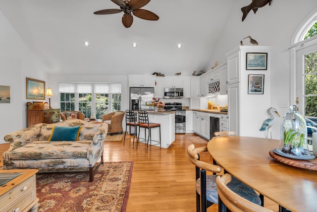 living area featuring high vaulted ceiling, a ceiling fan, light wood-style floors, and recessed lighting
