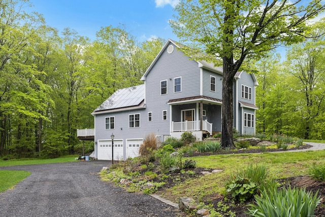 4 Aunt Park Ln, Newtown, CT 06470 - view of front of home with a garage, asphalt driveway, a porch, a standing seam roof, and metal roof