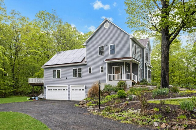 4 Aunt Park Ln, Newtown, CT 06470 - traditional home featuring a garage, driveway, a porch, roof mounted solar panels, and a standing seam roof