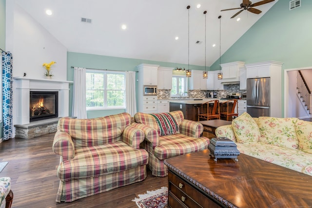 4 Aunt Park Ln, Newtown, CT 06470 - living area featuring a ceiling fan, a stone fireplace, high vaulted ceiling, dark wood-style floors, and stairs