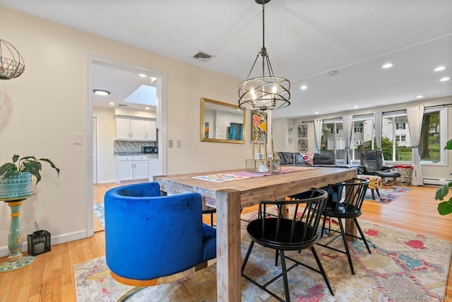 dining space featuring light wood-type flooring, visible vents, baseboards, a baseboard heating unit, and recessed lighting