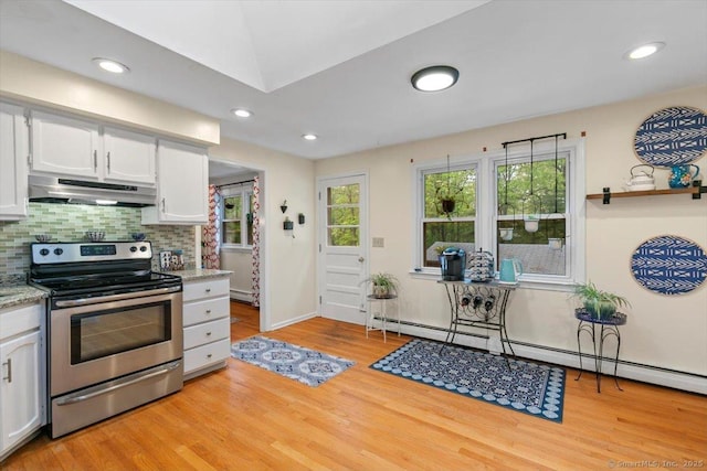 kitchen with electric range, under cabinet range hood, light wood-style flooring, baseboard heating, and white cabinets
