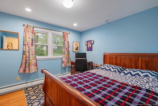 bedroom featuring baseboards, a baseboard radiator, recessed lighting, and wood finished floors