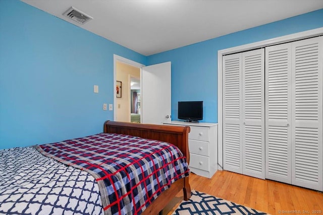 bedroom with a closet, light wood-type flooring, and visible vents