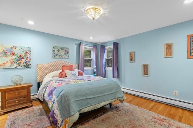 bedroom featuring baseboard heating, recessed lighting, and wood finished floors