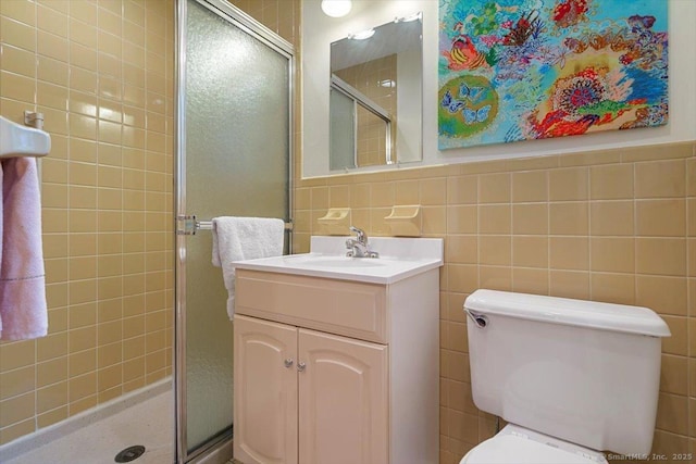full bath featuring tile walls, vanity, toilet, and a stall shower