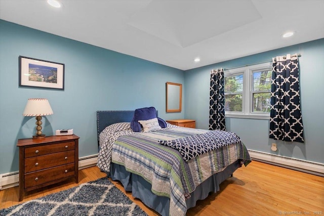 bedroom with a baseboard radiator, recessed lighting, and wood finished floors