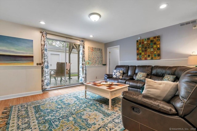 living area with wainscoting, recessed lighting, visible vents, and wood finished floors