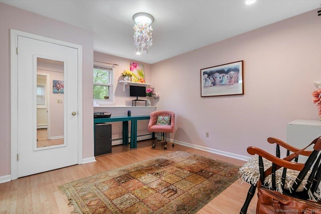 living area with light wood-type flooring, baseboards, and a baseboard radiator