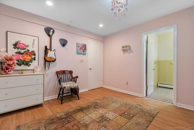 sitting room with baseboards, light wood-style floors, baseboard heating, and recessed lighting