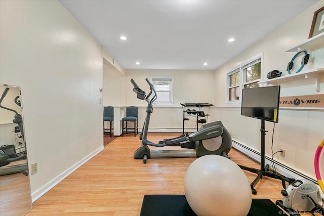 exercise room with a baseboard radiator, wood finished floors, baseboards, and recessed lighting