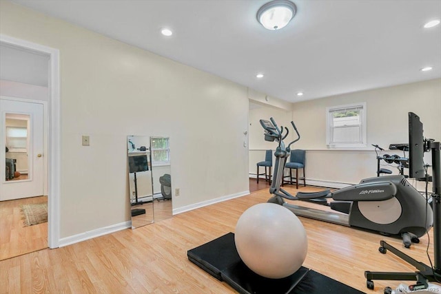 workout room featuring baseboards, recessed lighting, and wood finished floors