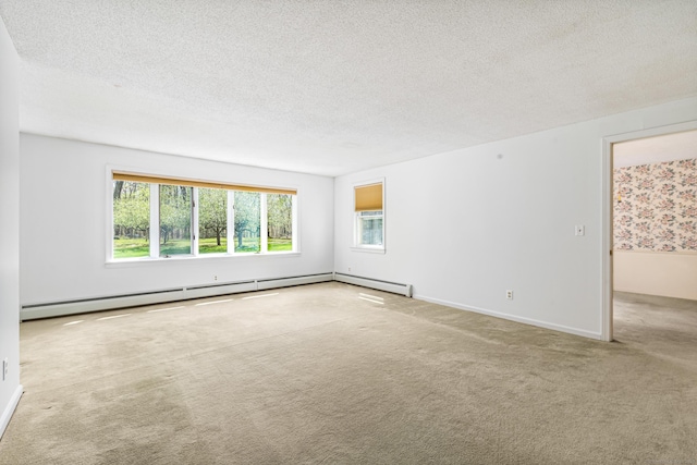 carpeted empty room featuring a textured ceiling and baseboards