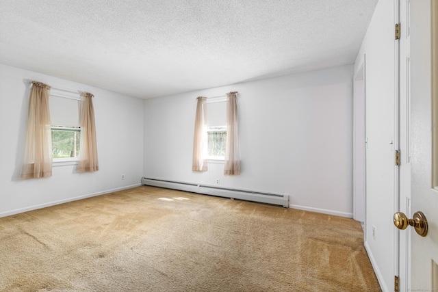 unfurnished room with baseboard heating, healthy amount of natural light, carpet floors, and a textured ceiling