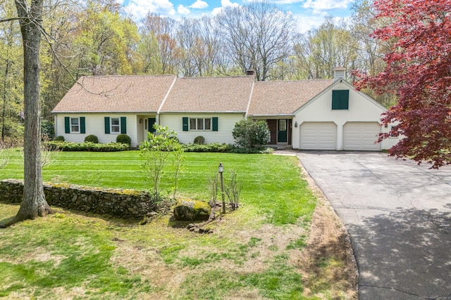 single story home with asphalt driveway, an attached garage, a chimney, and a front yard