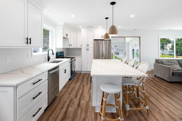 24 Sea Crest Ave, East Lyme, CT 06357 - kitchen featuring appliances with stainless steel finishes, a sink, a center island, a kitchen bar, and plenty of natural light
