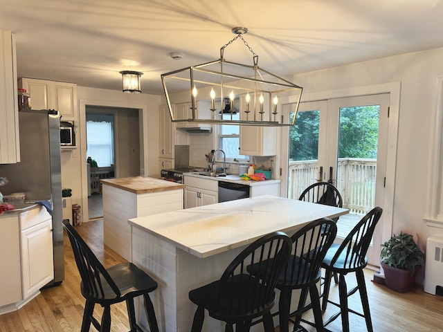 kitchen featuring a center island, butcher block countertops, plenty of natural light, and appliances with stainless steel finishes