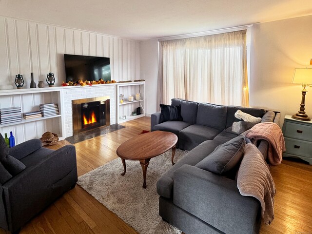 living room featuring wood finished floors and a brick fireplace