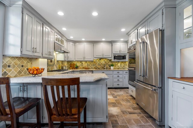 1696 Main St, Glastonbury, CT 06033 - kitchen with a sink, a peninsula, a breakfast bar, stone finish flooring, and appliances with stainless steel finishes