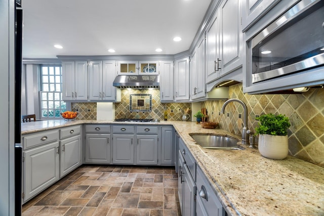 1696 Main St, Glastonbury, CT 06033 - kitchen featuring stainless steel microwave, a sink, under cabinet range hood, light stone countertops, and gray cabinetry