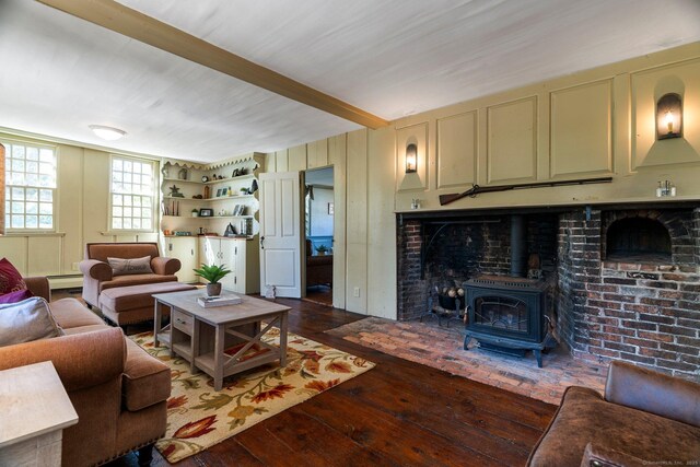1696 Main St, Glastonbury, CT 06033 - living room featuring a baseboard heating unit, beamed ceiling, a wood stove, and hardwood / wood-style floors