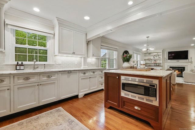 123 Richmond Hill Rd Unit 20, New Canaan, CT 06840 - kitchen with stainless steel microwave, a sink, ornamental molding, open floor plan, and wood finished floors