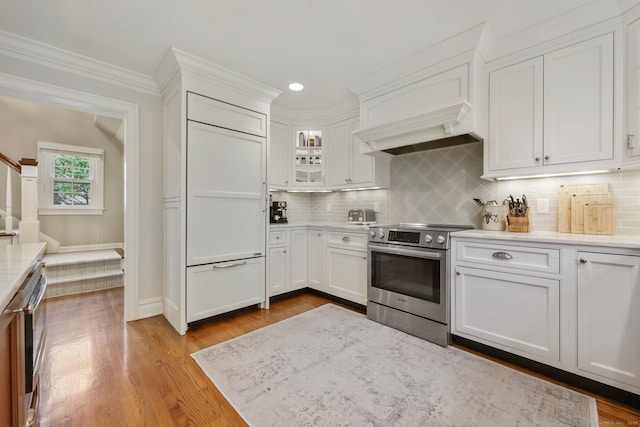 123 Richmond Hill Rd Unit 20, New Canaan, CT 06840 - kitchen featuring stainless steel electric stove, premium range hood, light countertops, white cabinetry, and ornamental molding