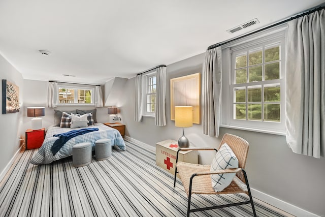 bedroom with baseboards, carpet, and multiple windows