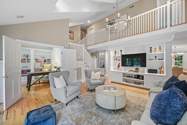 living area with high vaulted ceiling, a chandelier, wood finished floors, stairway, and recessed lighting
