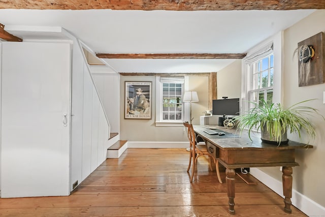 office featuring baseboards, light wood-type flooring, and beam ceiling