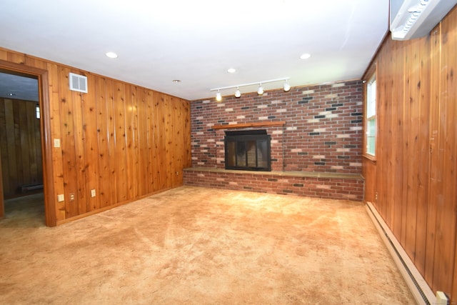 299 Valley Rd, North Branford, CT 06471 - unfurnished living room featuring baseboard heating, carpet flooring, wooden walls, a fireplace, and rail lighting