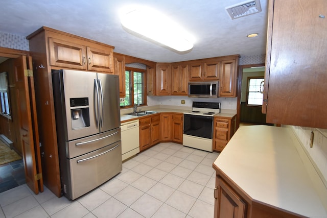 299 Valley Rd, North Branford, CT 06471 - kitchen with appliances with stainless steel finishes, light countertops, brown cabinetry, and a sink