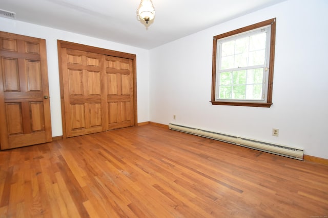 299 Valley Rd, North Branford, CT 06471 - unfurnished bedroom with a baseboard radiator, light wood-type flooring, baseboards, and a closet