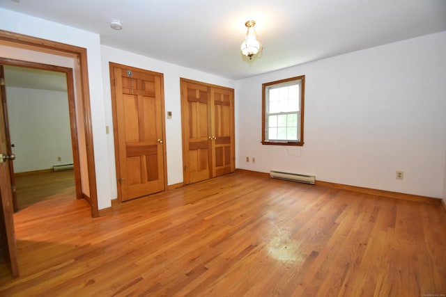 299 Valley Rd, North Branford, CT 06471 - unfurnished bedroom featuring baseboard heating, light wood-type flooring, and baseboards