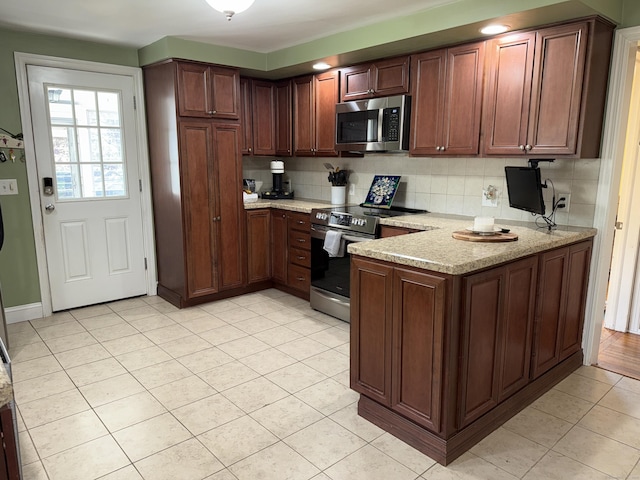 30 May St, Meriden, CT 06451 - kitchen with appliances with stainless steel finishes, a peninsula, tasteful backsplash, light tile patterned floors, and light stone counters